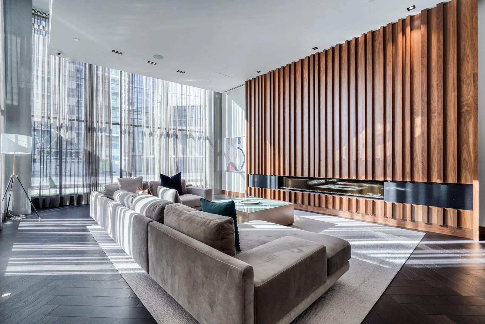 Sunlit lounge with a wood feature wall and fireplace